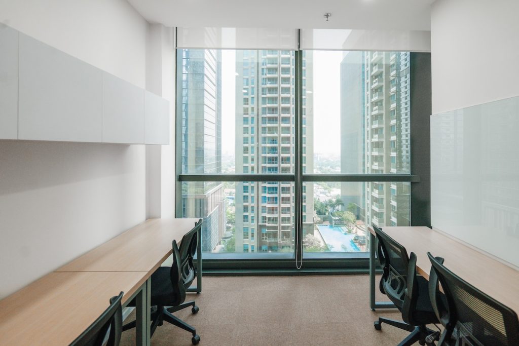 Interior ruang kerja serviced office modern dengan meja, kursi, dan fasilitas lengkap